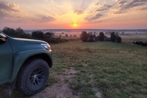 Pojazd SG Zachód słońca w tle, na pierwszym planie przód pojazdu Straży Granicznej