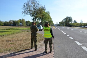 Kontrola ruchu drogowego Dwoje funkcjonariuszy SG stojących przy jezdni podczas kontroli ruchu drogowego