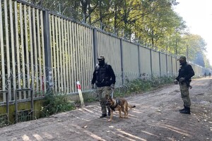 Pieszy patrol z psem Dwaj funkcjonariusze SG na pieszym patrolu z psem na pasie drogi granicznej, przy technicznej barierze