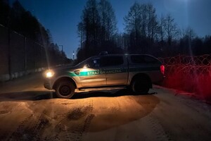 Nocny patrol SG Samochód SG stojący nocą na pasie drogi granicznej przy barierze technicznej