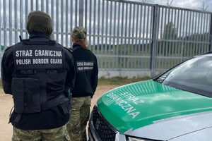 Funkcjonariusze na SG na granicy Funkcjonariusze SG stojący przy służbowym aucie na polsko - białoruskiej granicy