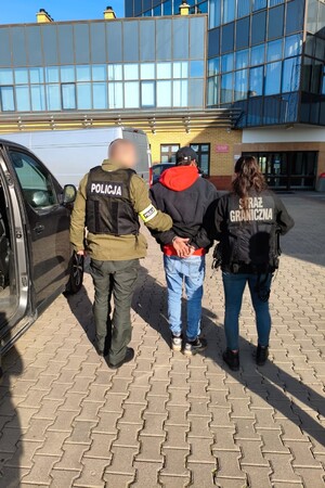 Zatrzymany za przemyt Funkcjonariusz Straży Granicznej i Policji prowadzą zatrzymanego