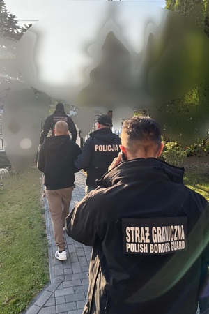 Zatrzymany za przemyt Funkcjonariusz Straży Granicznej i Policji prowadzą zatrzymanego