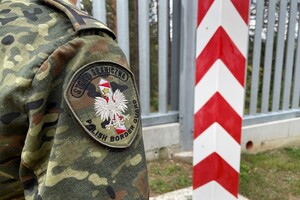 Słup graniczny Polski Słup graniczny Polski, po lewej kawałek funkcjonariusza z widocznym emblematem Straży Granicznej