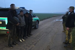 Zatrzymani migranci Czterech zatrzymanych migrantów stojących przy służbowym aucie SG