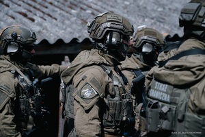 Wspólne ćwiczenia Straży Granicznej i Krajowej Administracji Skarbowej Funkcjonariusze stoją przy budynku.