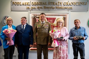 Odeszli na zasłużoną emeryturę komendant z pracownikami pozuje do zdjęcia