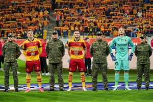 Funkcjonariusze Podlaskiego Oddziału Straży Granicznej na meczu Jagiellonii Białystok i Górnika Zabrze funkcjonariusze stoją z piłkarzami przed meczem
